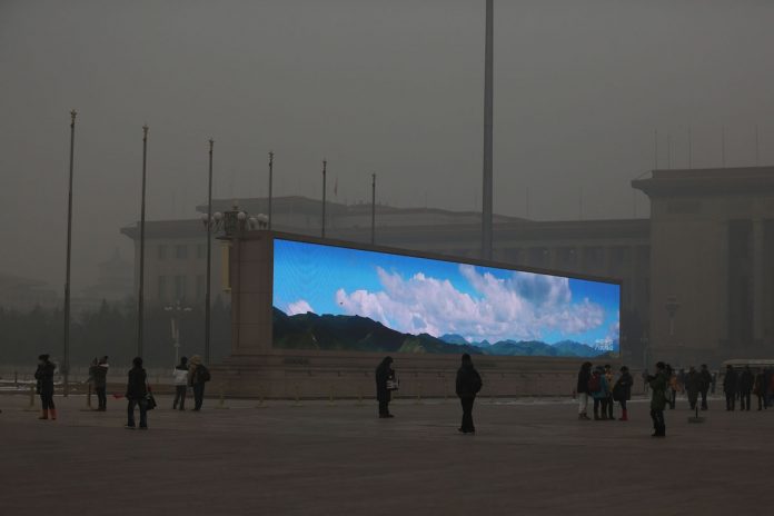 LED ekran z lepim vremenom v smoga polnem Pekingu