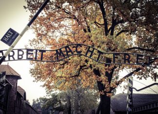 Jugoslovanski spomeniki na holokavst samevajo Napis: " Delo osvobaja" ob vhodu v Auschwitz.