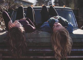 Generacija Z vs. Y dekleti ležita na pokrovu motorja