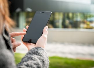 Kako varno očistiti svoj mobilnik? Mobilnik, ki ga nekdo drži v roki