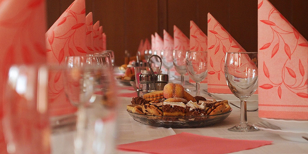 Obložena miza s kozarci, sladico, priborom in prtički