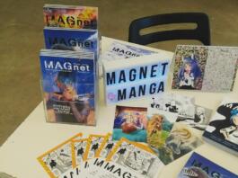 Stojnica revije MAGnet, kjer so revije, letaki, razglednice in koledar