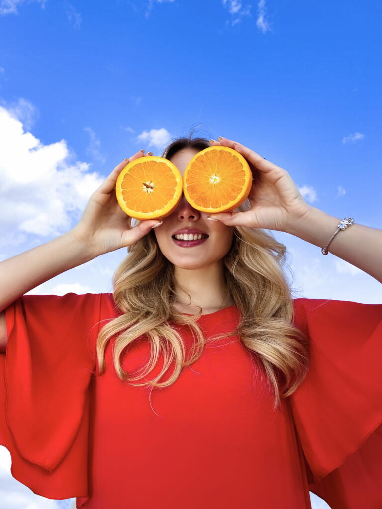 Ženska pred očmi drži polovici pomaranče