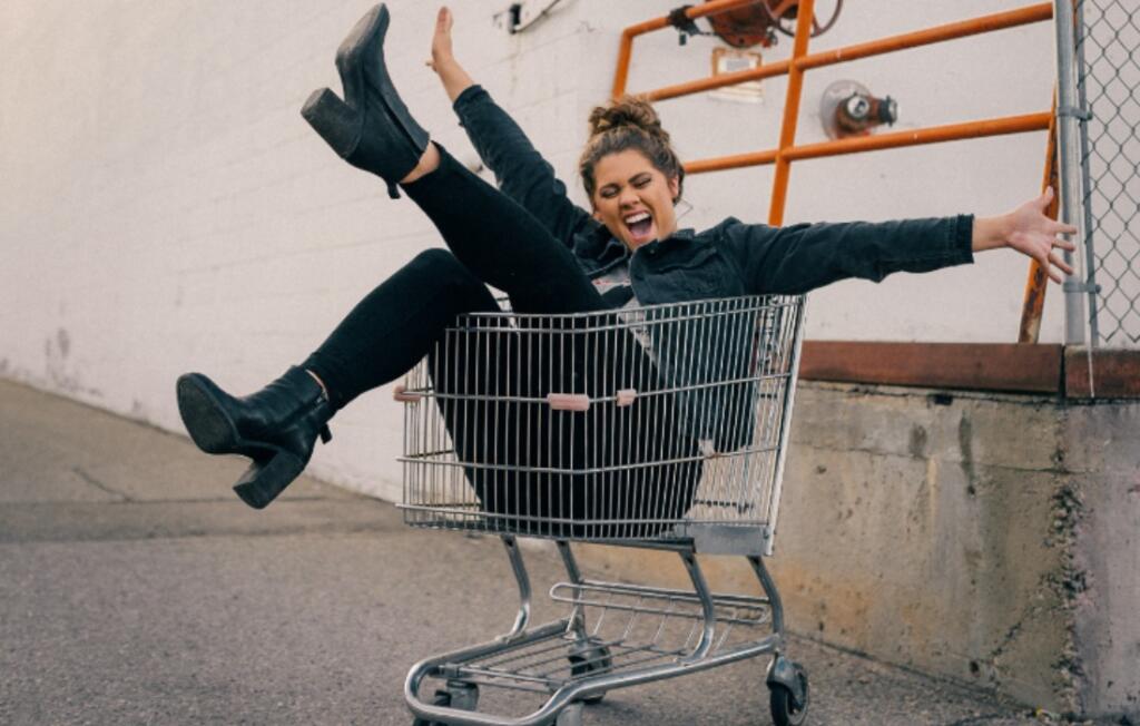Ženska sedi v nakupovalnem vozičku