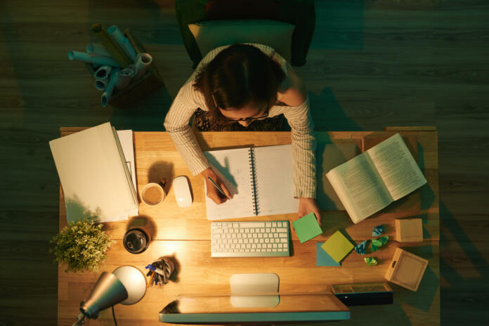 Female student doing homework, view from above