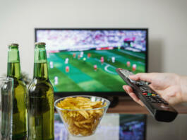 Televizija, na mizi čips in dve steklenici piva