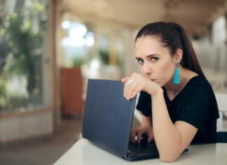 Spletni portal za študente obvešča: zamenjajte gesla Girl trying to keep her internet data confidential typing password in secret