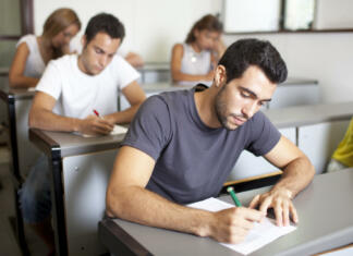 Sprejemni izpiti na fakultetah: Kateri faksi imajo preizkuse nadarjenosti? Good-looking male student writing an exam