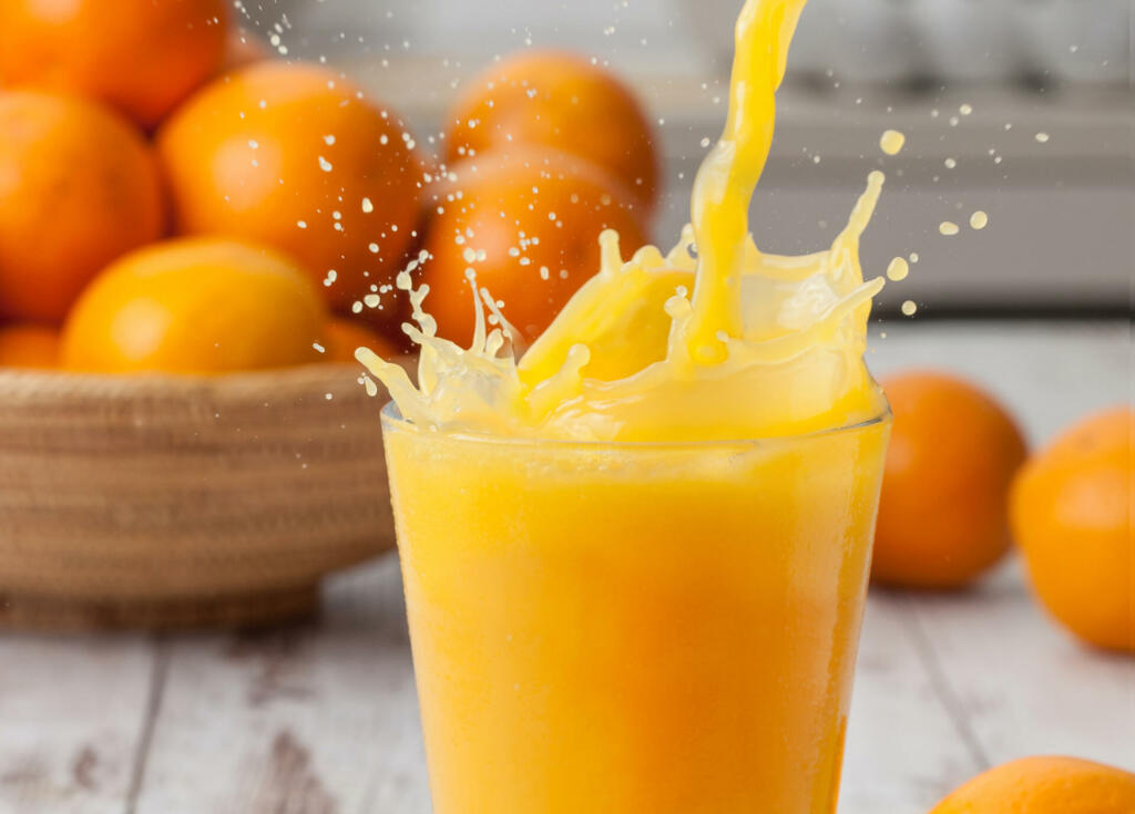 Pouring a glass of orange juice creating splash