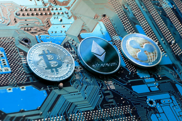 Prague, Czech Republic - May 23, 2018: Bitcoin, Ethereum and Ripple coins - largest cryptocurrencies by market capitalization lying on computer motherboard on May 23, 2018 in Prague, Czech Republic.