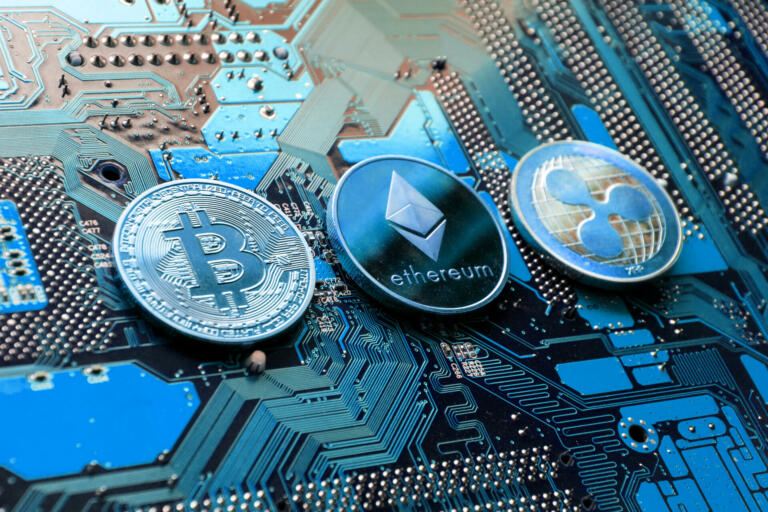 Prague, Czech Republic - May 23, 2018: Bitcoin, Ethereum and Ripple coins - largest cryptocurrencies by market capitalization lying on computer motherboard on May 23, 2018 in Prague, Czech Republic.