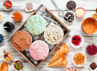 Sladoled, sorbet in frape: trije osvežilni recepti za vroče poletje Summer ice cream buffet with a variety of ice cream flavors and sweet toppings. Overhead view table scene on a rustic white wood background.