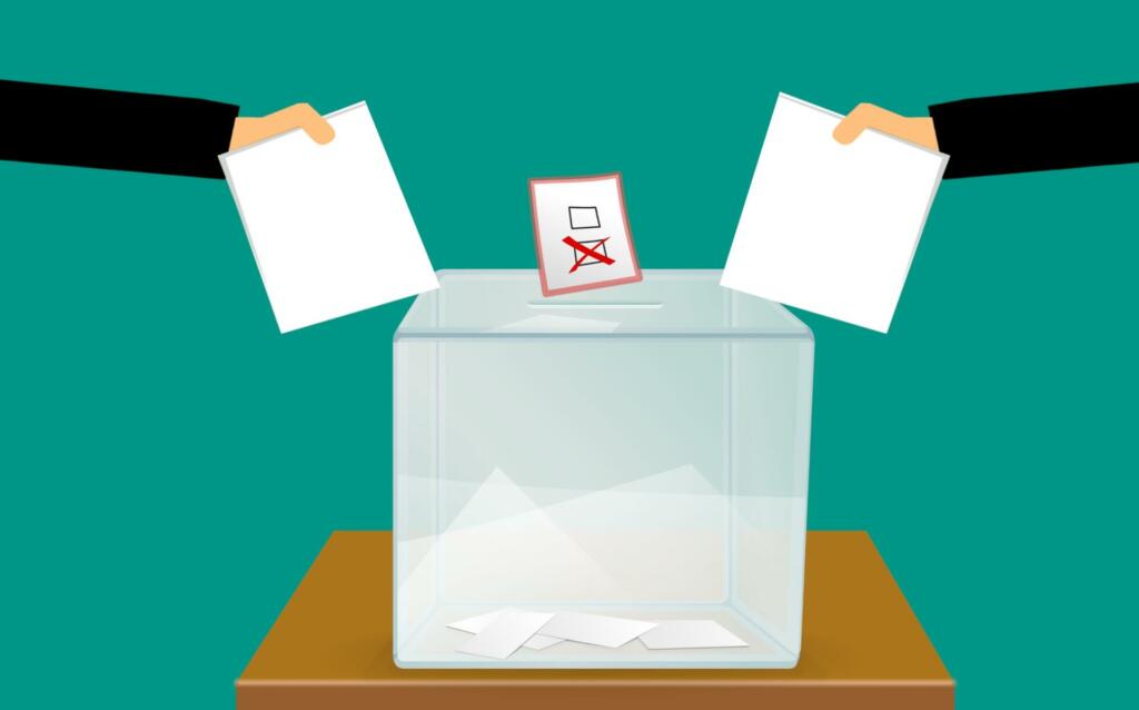 grafika dveh rok, ki v volilno skrinjico mečeta list