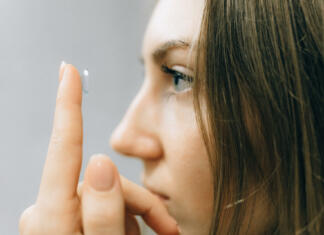 Kontaktne leče bi lahko pomagale zdraviti glavkom Ženska na prstu pred obrazom drži kontaktne leče