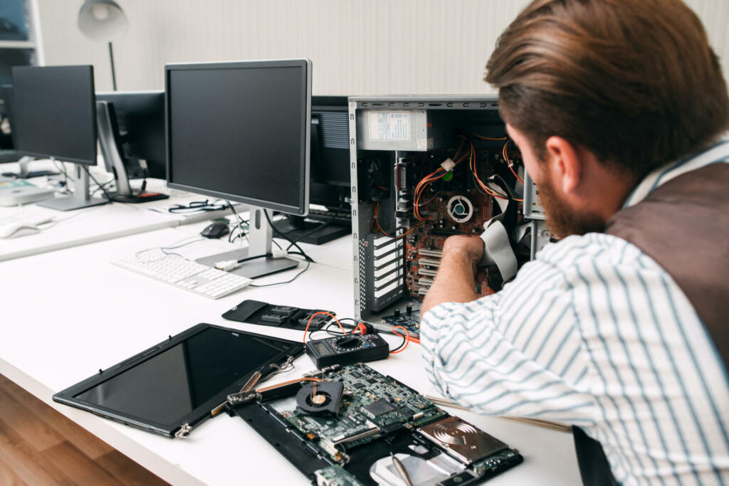 Moški popravlja računalnik
