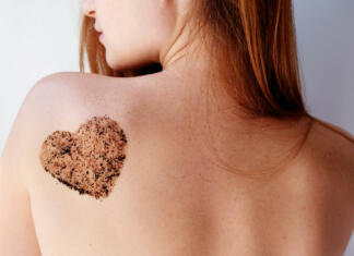 Zakaj je piling kože tako pomemben? Ženska ima na golem hrbtu narisan srček iz kavnega pilinga