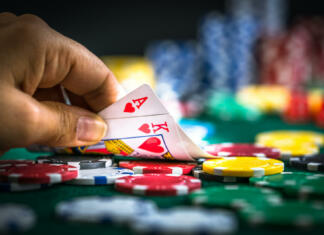 “Ne zakockaj svoje prihodnosti” Gambling Hand Holding Poker Cards and Money Coins Chips