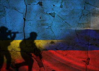 Pravi razlog, zakaj Rusija napada Ukrajino (ni to, kar misliš) Russia vs Ukraine flag on cracked wall, concept of war between russia and ukraine, silhouette of soldiers on russia vs ukraine flag