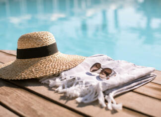 Klobuk in sončna očala ob bazenu