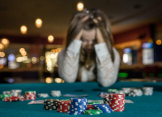 “Ne zakockaj svoje prihodnosti” Upset woman in casino sitting behind poker table