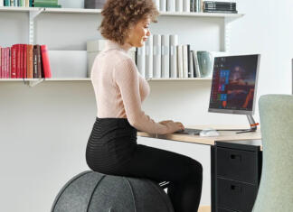 Kaj je pilates žoga? Ženska sedi na Pilates žogi CORBRIDGE