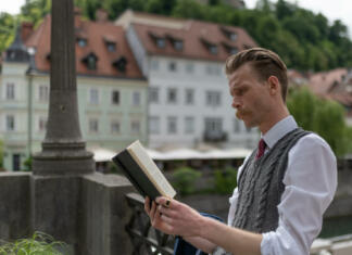 Spoznajte netopirje v Županovi jami pri Grosupljem A young hipster man with a mustache on a walk around the city drinking coffee, reading a book .