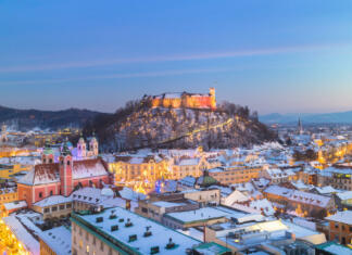 Praznično decembrsko dogajanje v Ljubljani Aerial panoramic view of Ljubljana decorated for Christmas holidays. Roofs covered in snow in winter time. Slovenia, Europe.