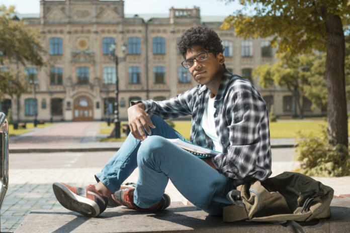 African American boy student stands near the Polytechnic University in Kiev.