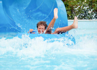 Popusti za sprostitev an 8 year old boy is riding in the water Park on inflatable circles on water slides.