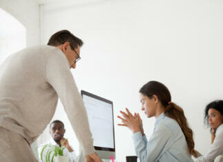 Spolno nadlegovanje doživelo četrt Slovencev Angry boss scolding criticizing firing stressed intern for incompetence in multiracial office, sad frustrated employee receives unfair reprimand rebuke, suffers from bad attitude of executive at work