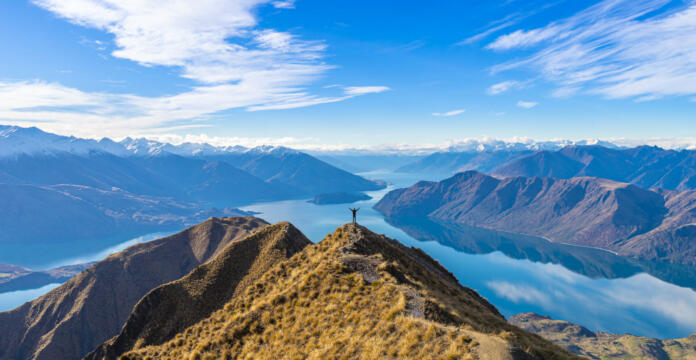 Asian traveler celebrating success at Roy's Peak Lake Wanaka New Zealand