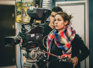 Drugi in tretji vpisni rok v dodiplomski študij Behind the scene. Cameraman and assistant shooting the film scene with camera in film studio