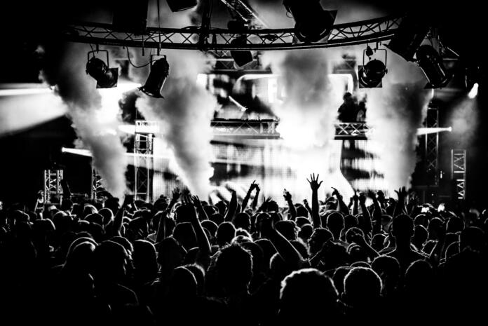 Black and white DJ crowd in nightclub party with ice canon and smoke machine