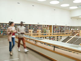 Blurred motion of people walking along the corridor in big library