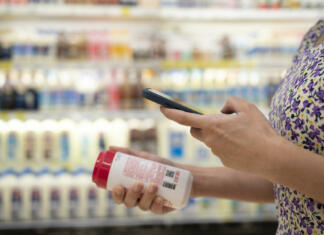 Kaj je Google Wallet in zakaj bi ga uporabljali? close up of asian young businesswoman is shopping for meat and scanning barcode with smart phone at supermarket