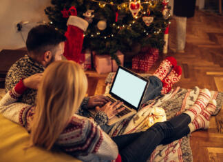 Božični filmi Couple enjoying Christmas mood while surfing the net together.
