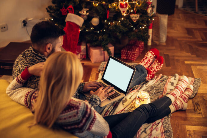 Couple enjoying Christmas mood while surfing the net together.