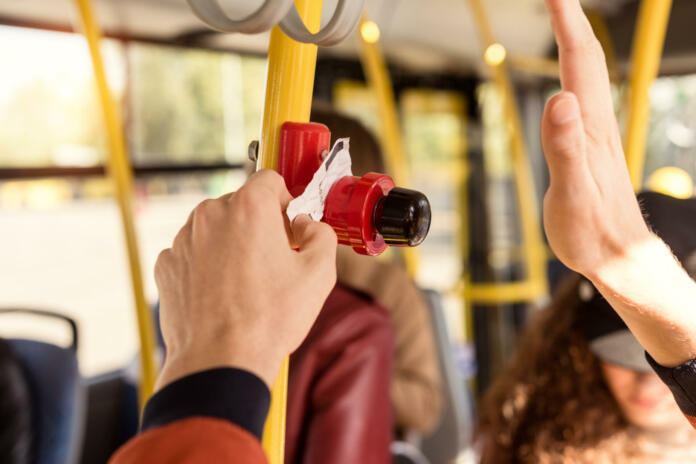 cropped shot of man validating bus ticket in public transport