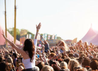 Študenti in dijaki tudi letos ugodneje na Festival Lent Crowds Enjoying Themselves At Outdoor Music Festival With Arms in The Air