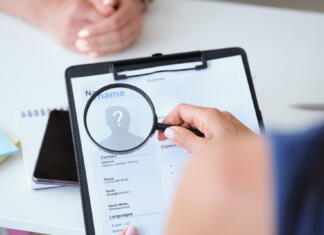 Naučite se napisati zmagovit življenjepis in spremno pismo! Employer looking at worker resume with magnifying glass closeup. Recruitment concept