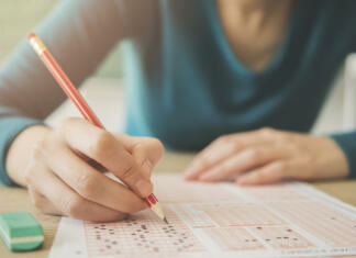 IZPITI, IZPITI, IZPITI! Female student holding pencil and examination paper
