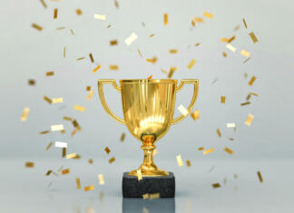 Zgodbe ozadja Lige prvakov (sreda) Gold winners trophy, champion cup with falling confetti on gray background. 3D rendering