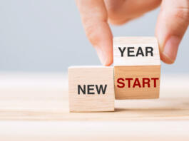 hand flip wooden block with New Year to New Start text on table background. Resolution, strategy, solution, goal, business and holiday concepts