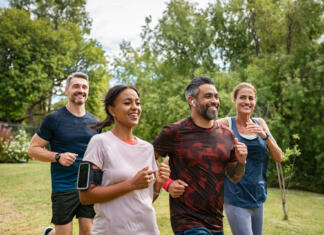 Športna aktivnost in zdravje pozimi Healthy group of multiethnic middle aged men and women jogging at park. Happy mixed race couples running together. Mature friends running together outdoor.