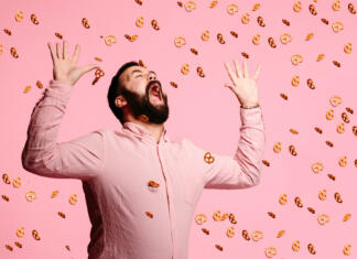 Upad števila študentov Man trying to eat flying pretzels