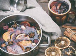 mulled wine in an iron saucepan on a brown wooden table,  top view