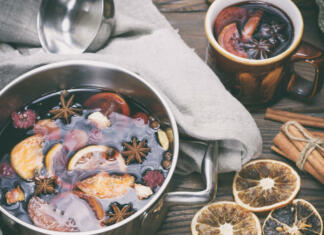 Pozimi prija kuhano vino ali punč mulled wine in an iron saucepan on a brown wooden table, top view