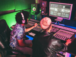 Musician and sound engineer mixing new album inside boutique recording studio - Technology and music industry concept - Main focus on man head