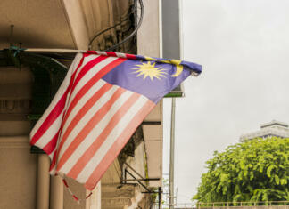 Malezijski Borneo Old torn and dirty Malaysia flag in big city Kuala Lumpur, Malaysia.