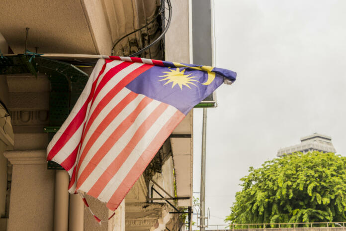 Old torn and dirty Malaysia flag in big city Kuala Lumpur, Malaysia.
